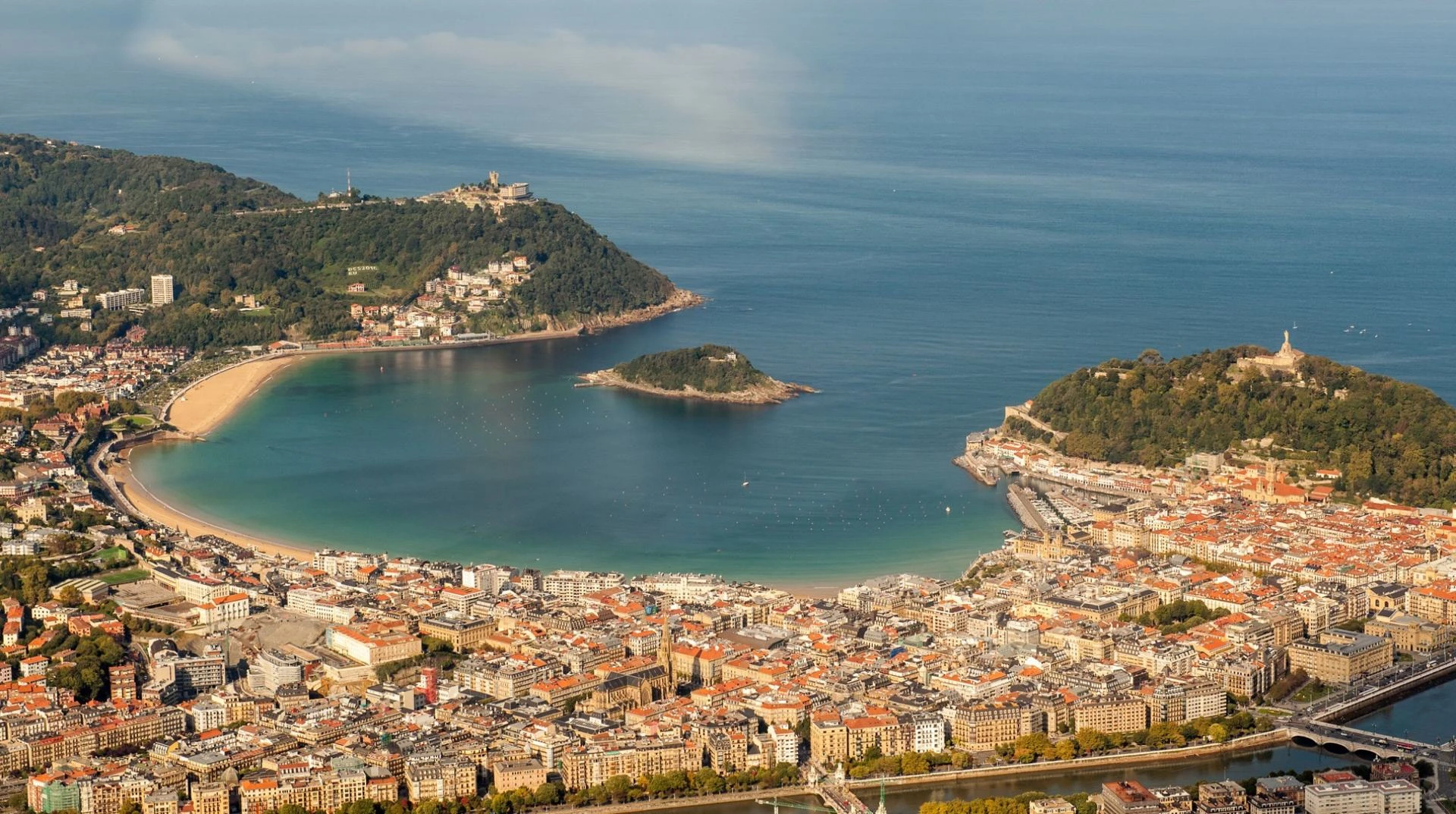 Aerial view of San Sebastián showing La Concha Bay, Santa Clara Island, the Old Town and the surrounding Basque coastline.